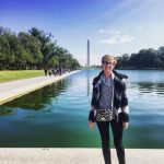 A young blond woman standing in front of the reflection pool with the Washington Monument in the background