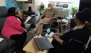 Veterean, interviewer, and stenographer in a living room