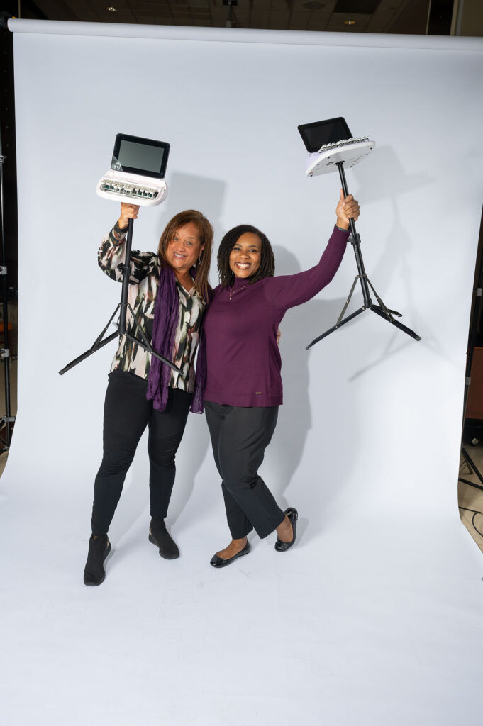 Reporters smiling and holding their steno machines in the air