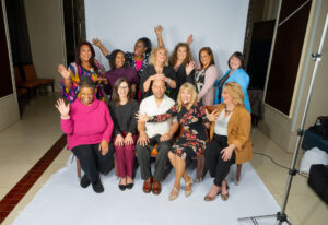 A group of reporters posing and smiling at a photo shoot for Boot Camp