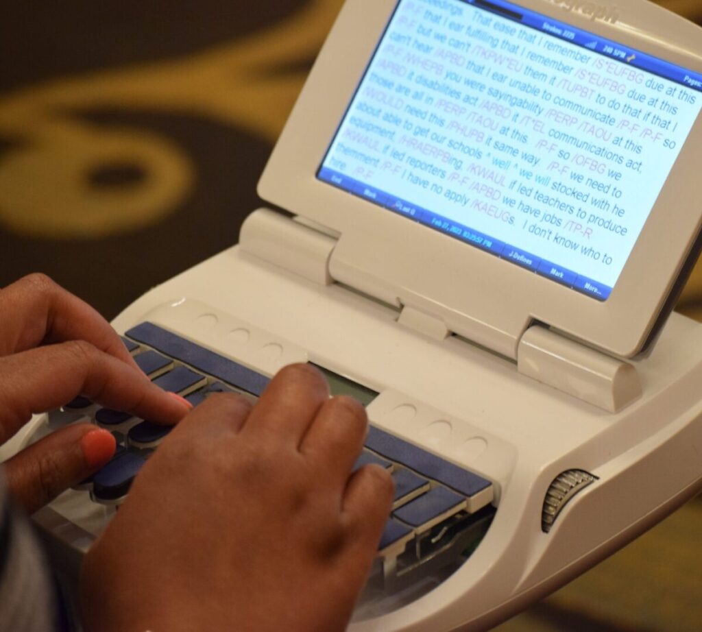 Hands typing on a Steno machine