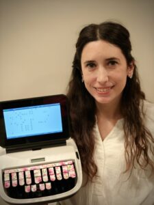 Woman smiling and holding steno machine